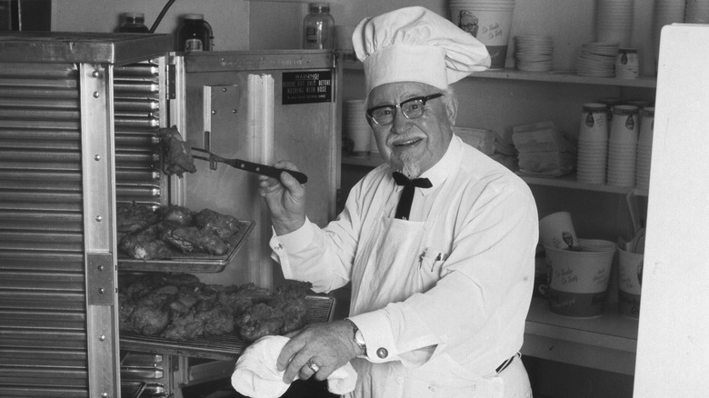 Colonel Sanders with a tray of fried chicken
