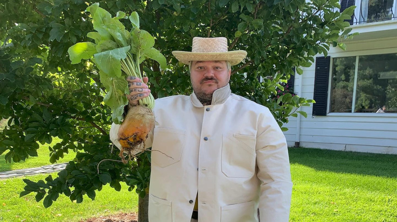 Matty Matheson models a Rosa Rugosa outfit while also holding up some farm produce