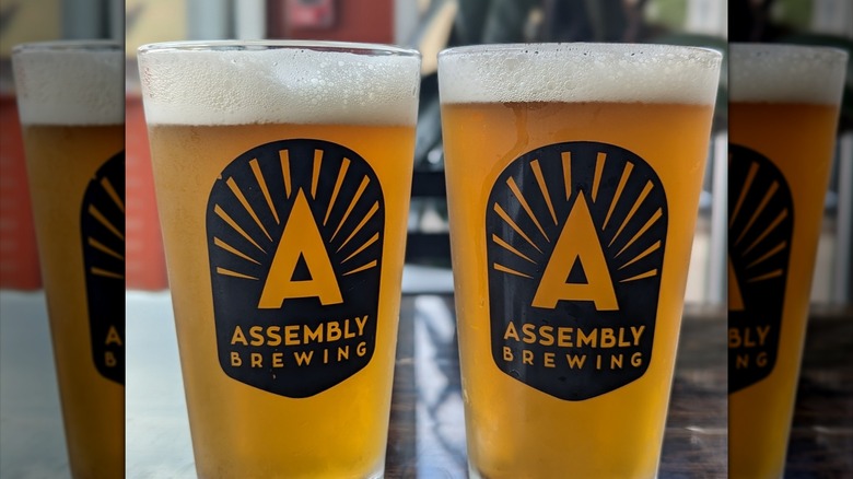 two full Assembly Brewing pint glasses