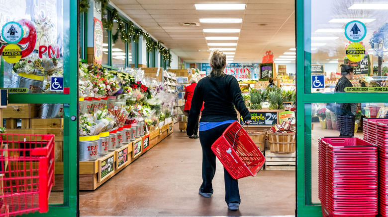 Woman with basket walks into Trader Joe's