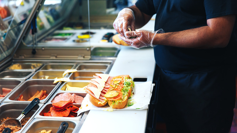 fast-food worker making sandwiches