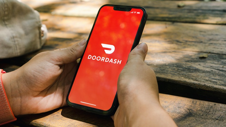 Person with DoorDash app on phone at picnic table