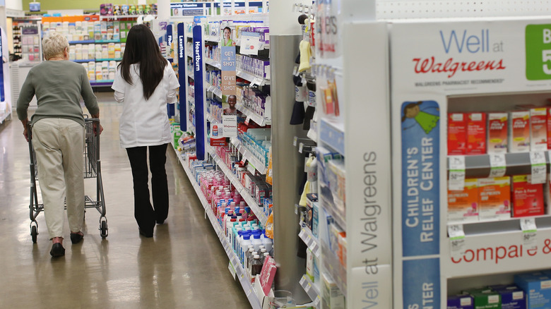 Pharmacist an customer strolling aisles at Walgreens