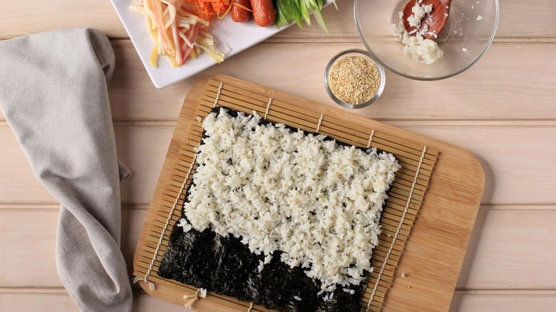 nori and rice next to sushi ingredients