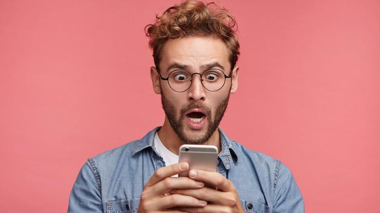 Person looking shocked holding phone