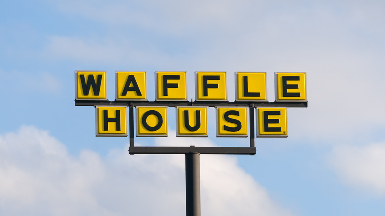 Waffle House sign with clouds behind