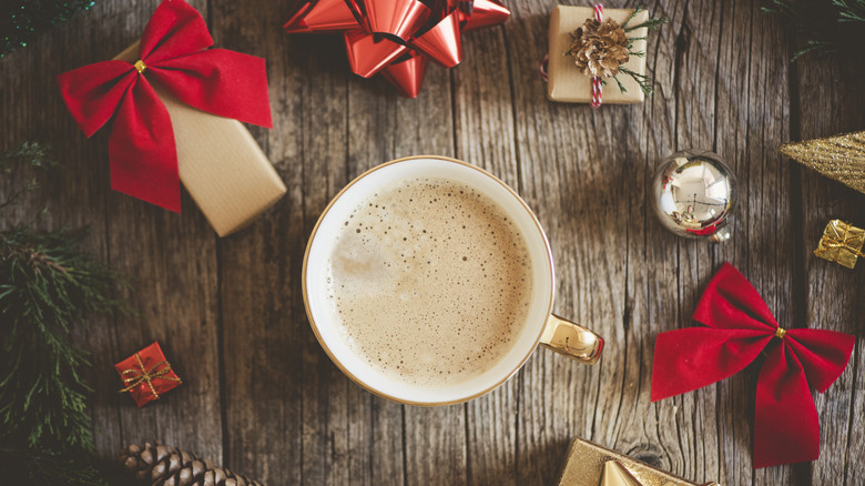 overhead view of coffee cup surrounded by Christmas decorations