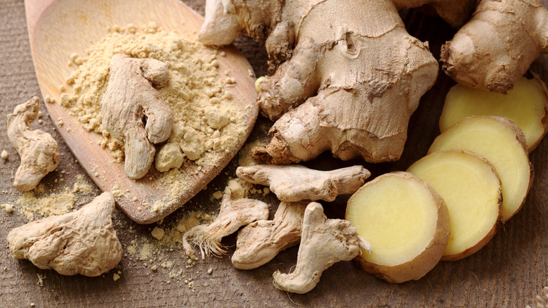 Fresh and ground ginger root with a wooden spoon