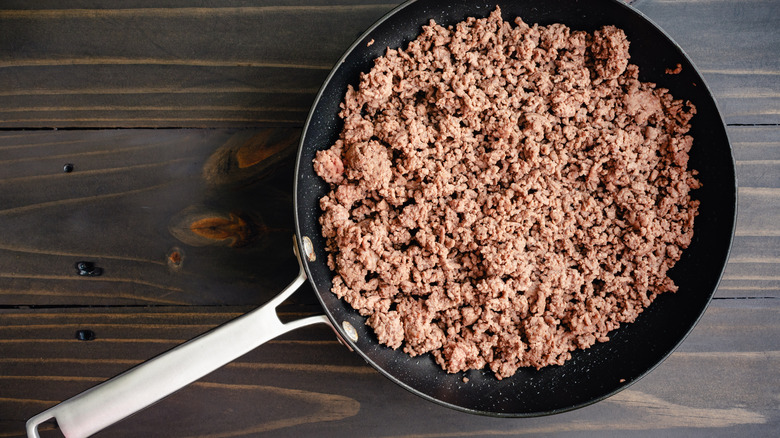 Pan of ground beef on wooden surface