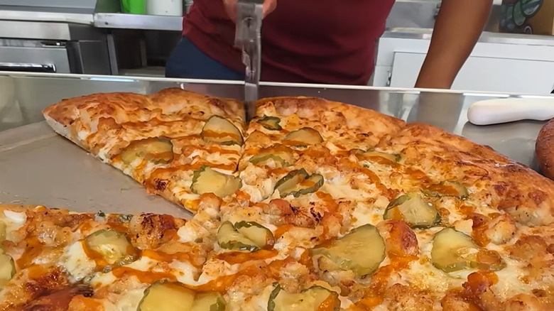 Pickle Me Hot Chicken Pizza on food stall counter