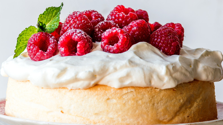 Cake topped with whipped cream and raspberries