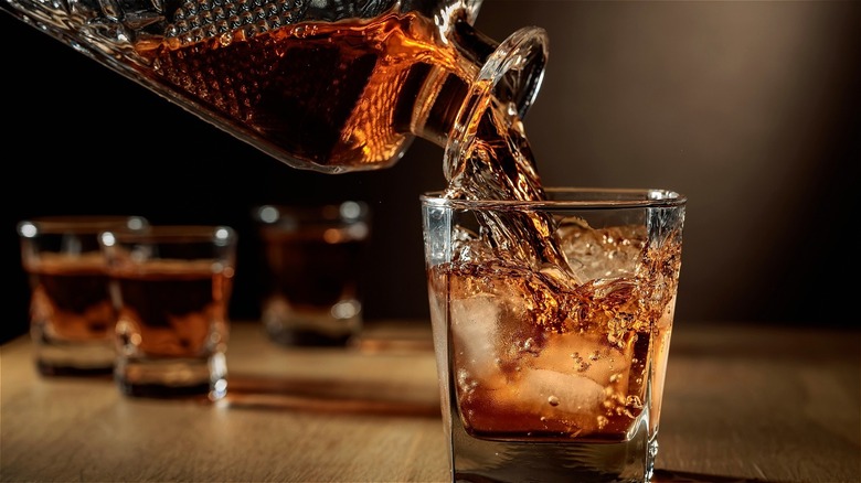 Whiskey being poured from a decanter into a glass