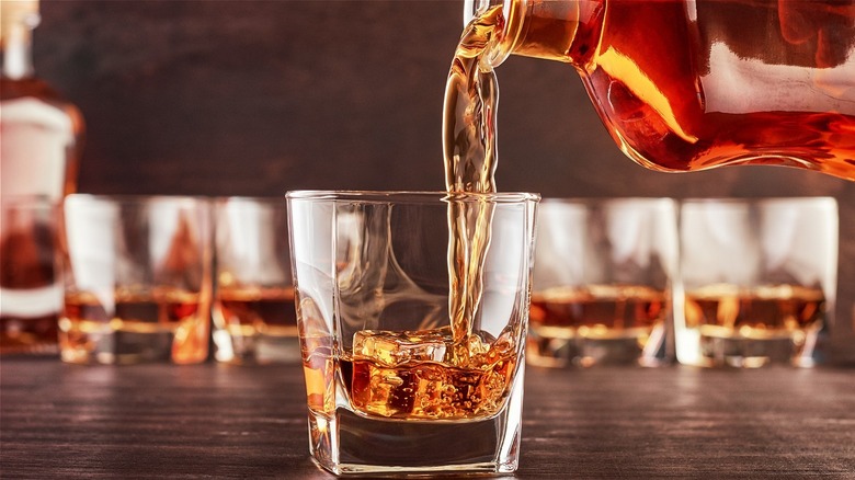 Whiskey being poured from a bottle into a glass