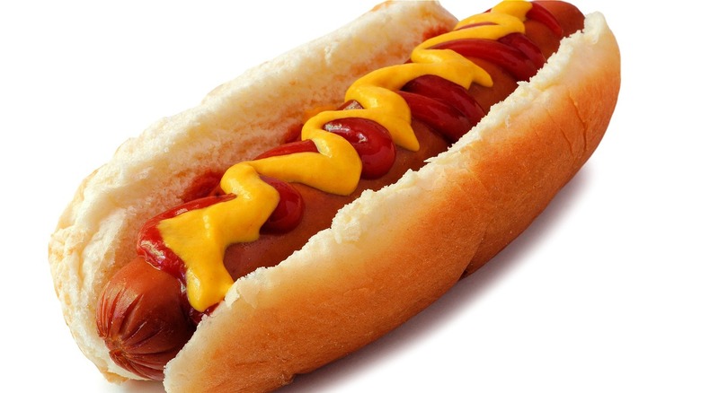 A hot dog in a bun with mustard and ketchup