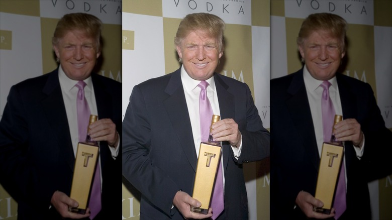 Trump holding bottle of Trump Vodka