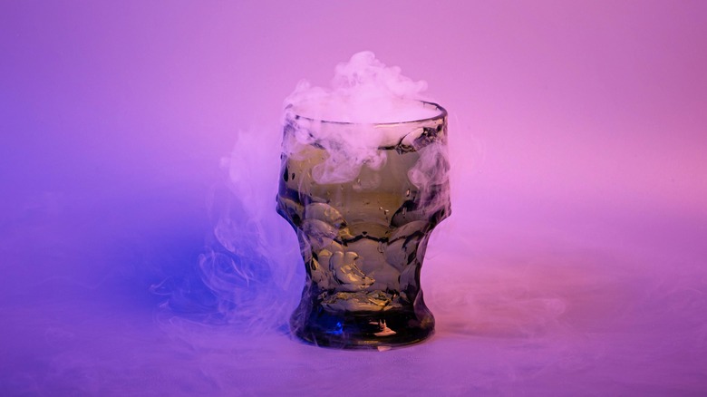 a smoking green drink on a purple background