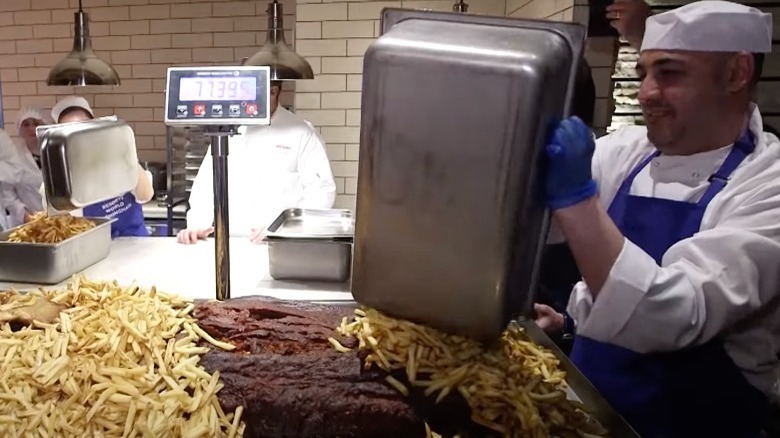 Man dumping pan of chips