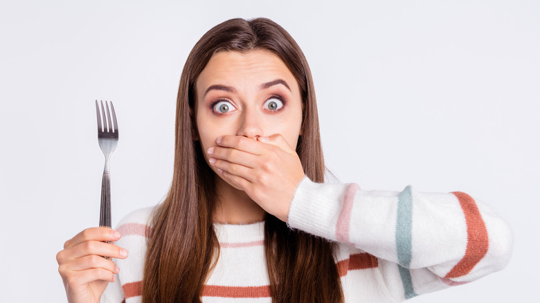 shocked woman holding spoon