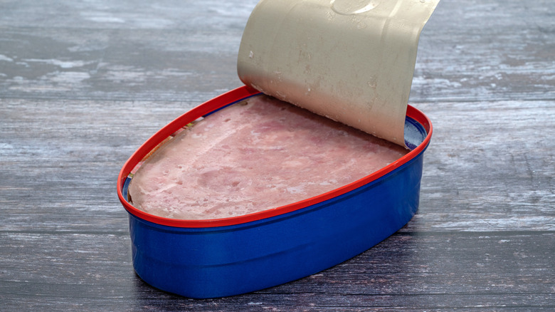 Open can of cooked ham on table