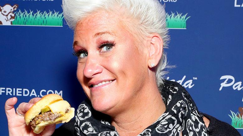 Anne Burrell holding a cheeseburger