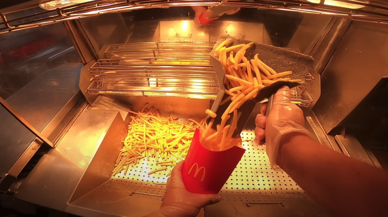 worker putting fries in box