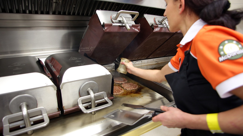 woman cooking burgers at McDonald's