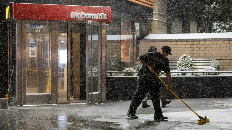 employee clearing snow at McDonald's
