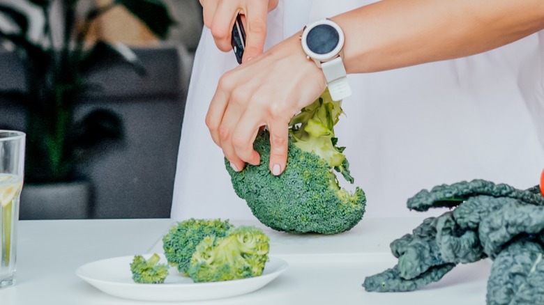 Woman cuts broccoli