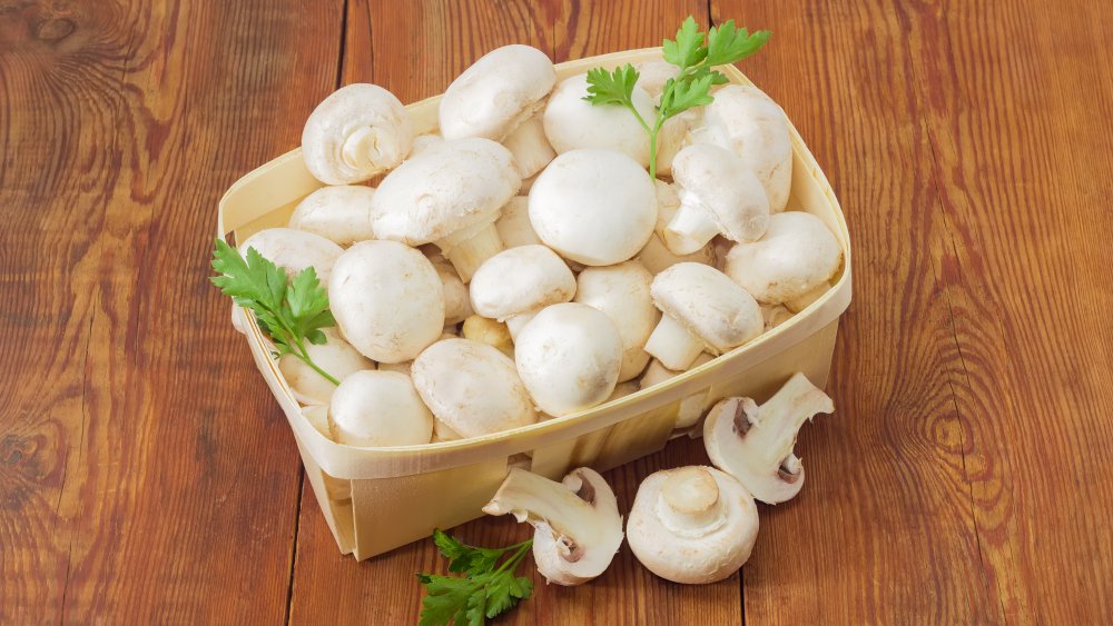 White button mushrooms in a basket