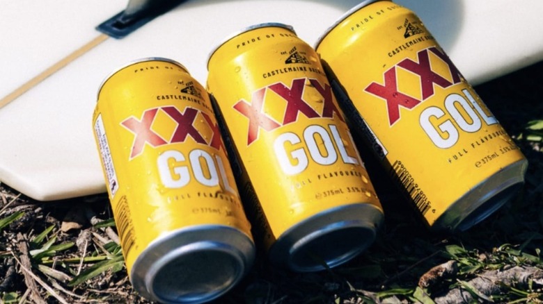 XXXX beer cans by surfboard