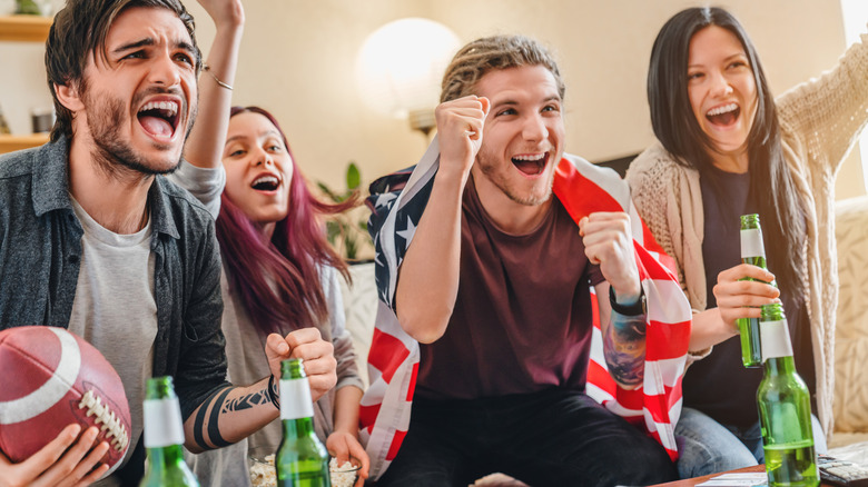 Group of friends drinking beer and cheering