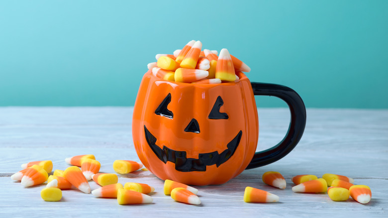 Candy Corn overflowing from pumpkin mug 