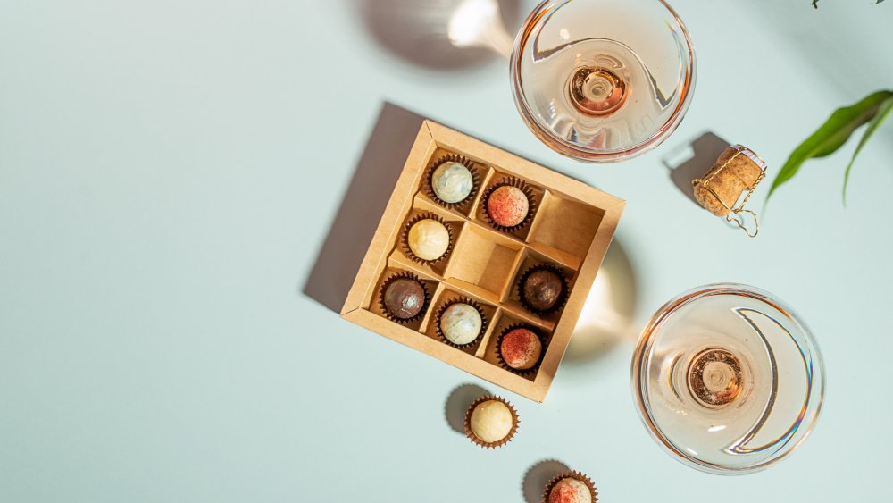 Glasses of wine with a box of colorful chocolates