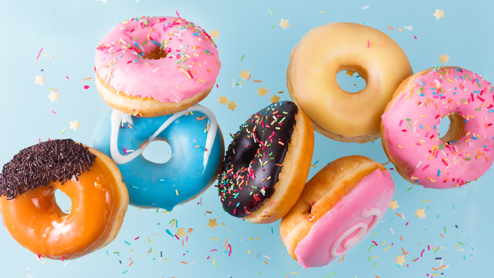 Colorful doughnuts and sprinkles on a blue background