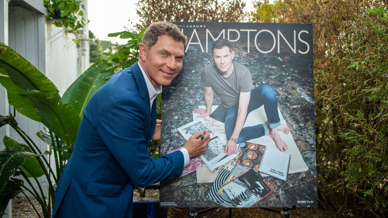 Bobby Flay signing the cover of Hamptons magazine