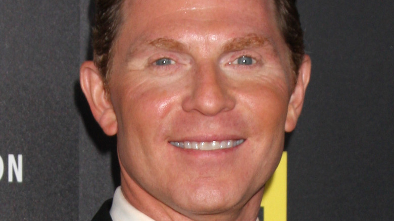 Bobby Flay smiling against black backdrop