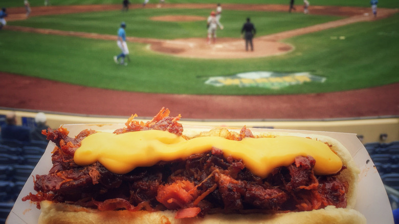 Chili cheese hot dog with view of ballpark in background