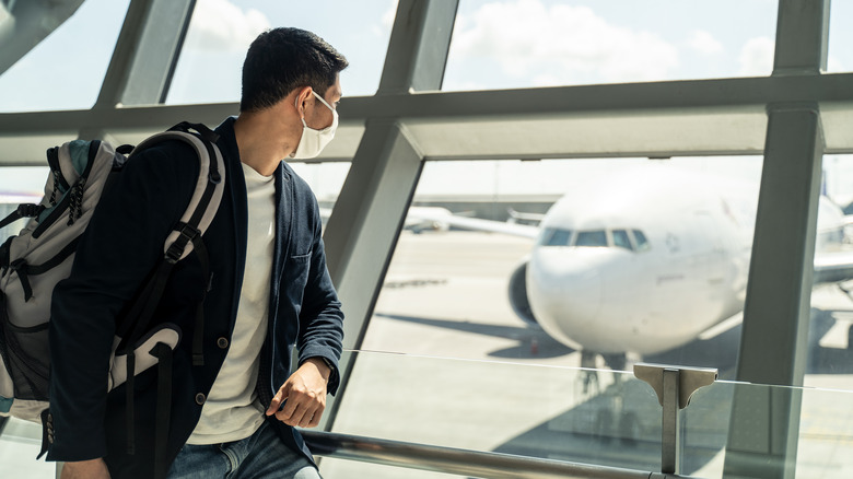 Person in airport looking at plane