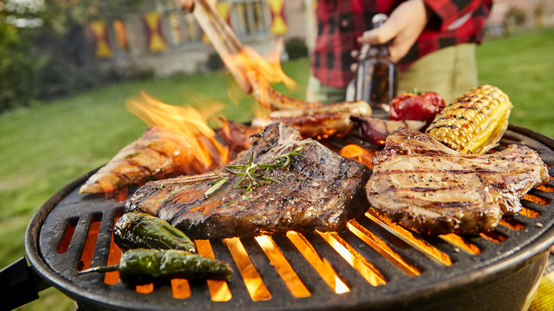 A person grilling meat outdoors