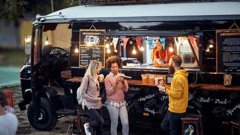 people mingling in front of food truck