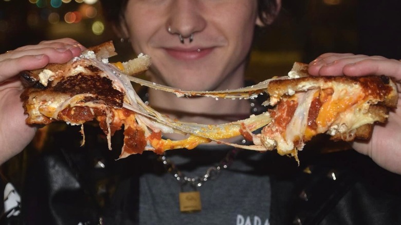 Person separating grilled cheese with their hands