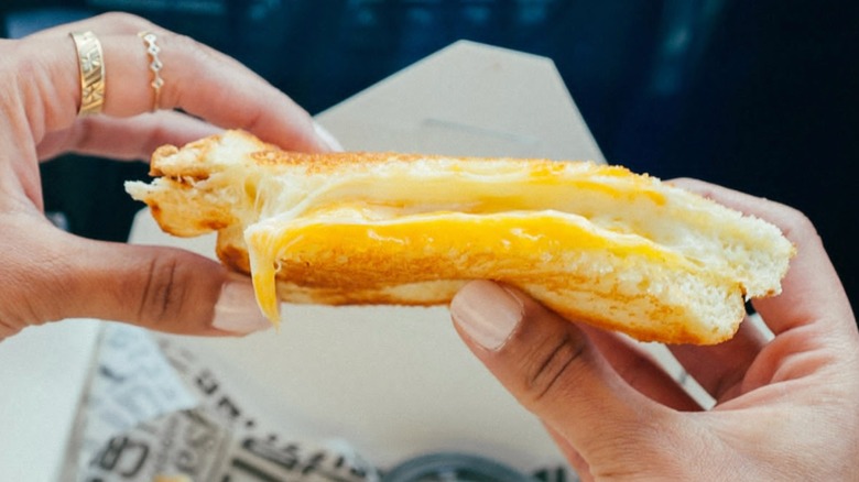 hand grabbing grilled cheese