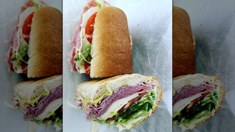 Italian sub packed with cold cuts, cheese, lettuce, and tomatoes