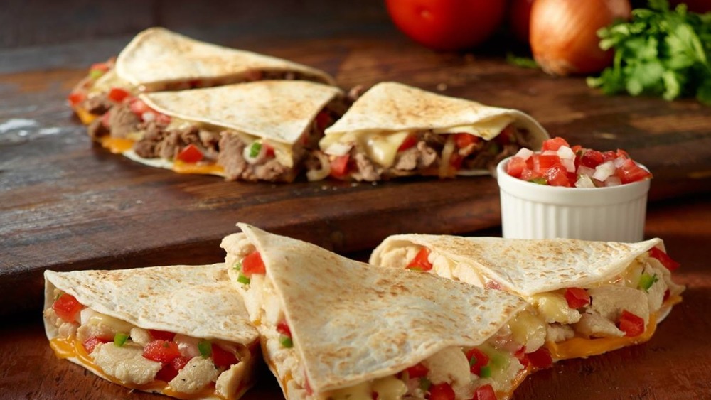 Wawa quesadillas on a wooden surface with fresh salsa 