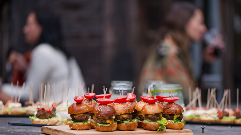 Fancy fast food bites with blurred people socializing in the background