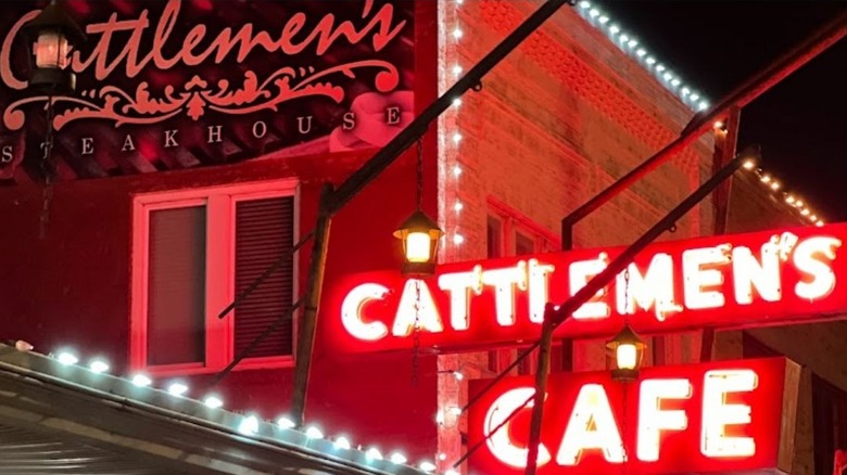 The front entrance to Cattlemen's Steakhouse with a glowing Cattlemen's Cafe sign