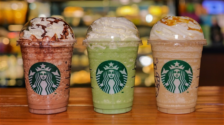 Three Starbucks frappuccinos with whipped cream on top 