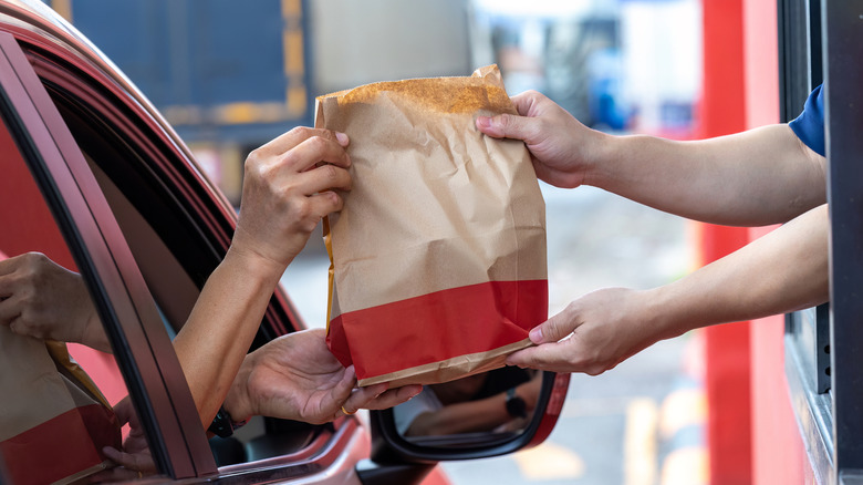 A fast food bag handover in a drive-thru