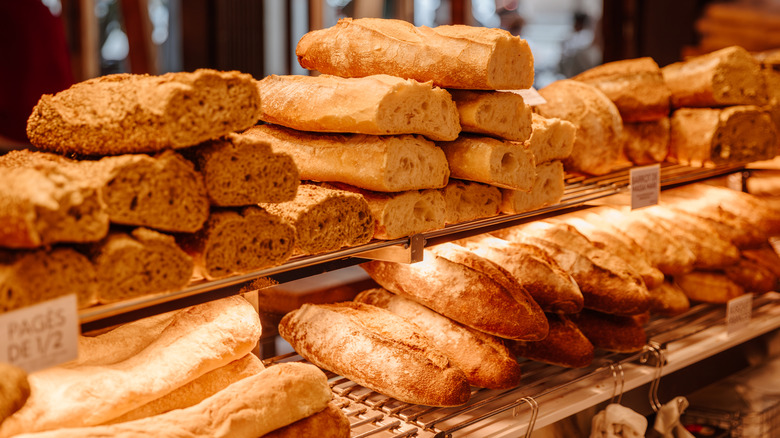 A variety of loaves of bread stacked up in a bakery