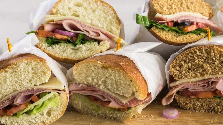 Subs wrapped in parchment paper on wooden board